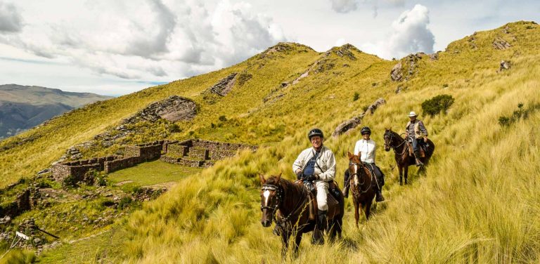 A group of people horseback riding around the Cusco outskirts